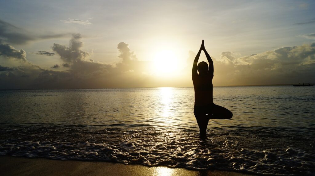 Anupama Wellness website homepage showcasing silhouetted figures practicing yoga by the water at sunset, promoting holistic health-UK.jpg